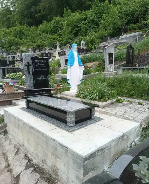 Одинарний пам'ятник із чорного граніту Габро з різьбленим кам'яним хрестом та гранітною лампадою.