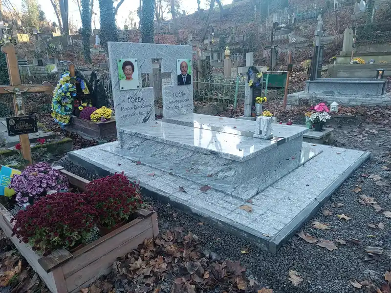 Подвійний пам'ятник зі світлого Viscont White граніту Покостівка з кольоровим фотосклом та широким гранітним відмощенням.