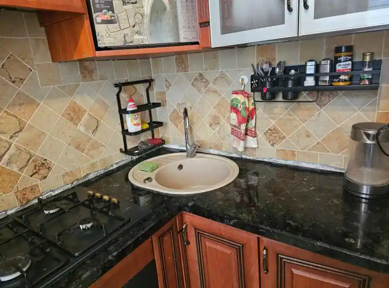 Кутова стільниця з натурального зеленого лабрадориту на класичній кухні, виготовлення та монтаж кам'яних поверхонь, Львів — Майстерня Пилипчук