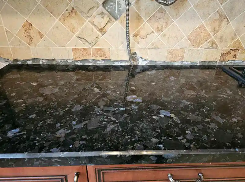 Крупний план текстури чорного граніту з синіми кристалами, дзеркальна поверхня кухонної стільниці, натуральний камінь лабрадорит, Львів — Майстерня Пилипчук